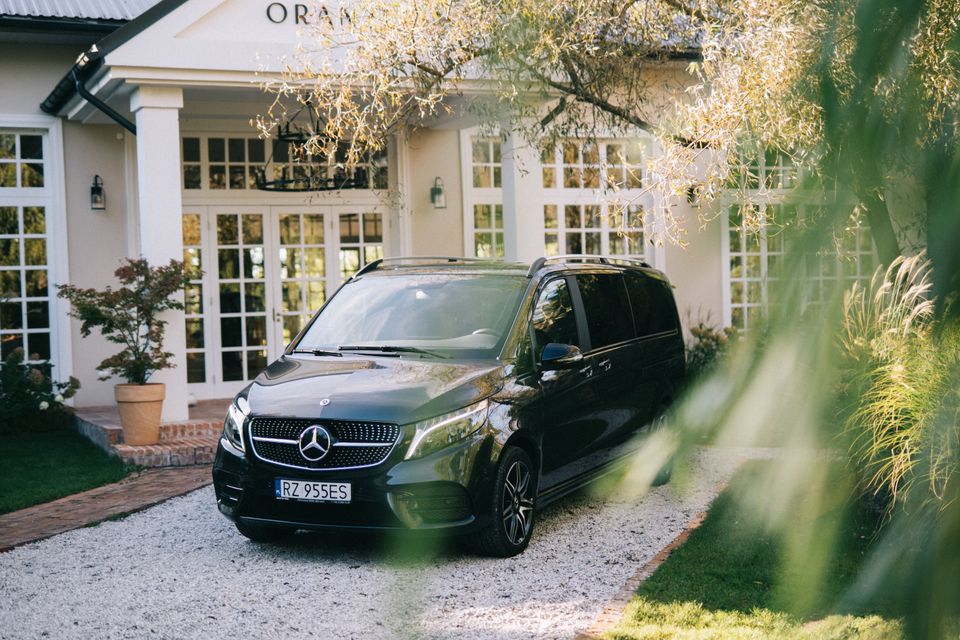 Mercedes V-Class zaparkowany na tle sali weselnej.